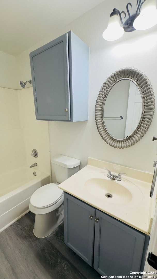 full bathroom with vanity, hardwood / wood-style floors, toilet, and shower / washtub combination