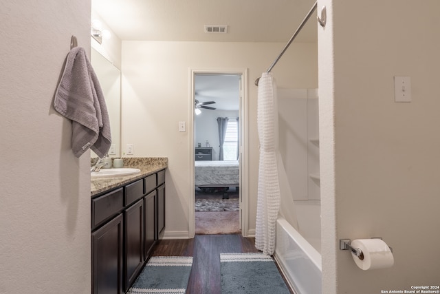 bathroom with shower / bathtub combination with curtain, vanity, ceiling fan, and hardwood / wood-style floors