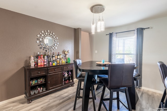 dining room with light hardwood / wood-style floors and indoor bar