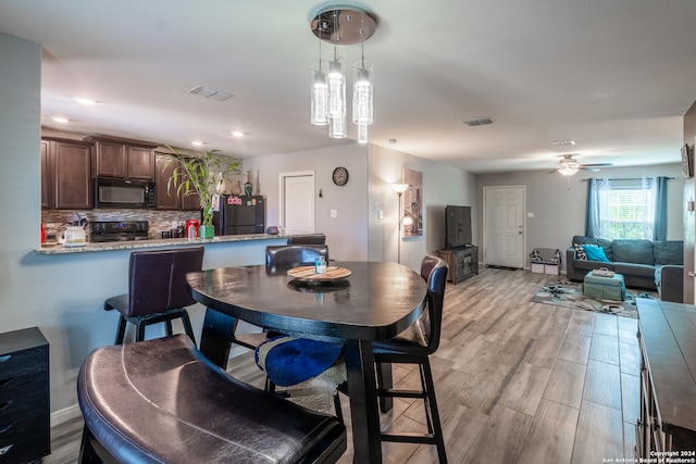 dining room with light hardwood / wood-style floors and ceiling fan