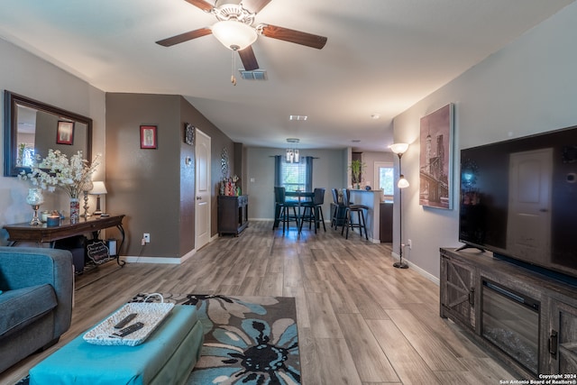 living room with light hardwood / wood-style floors and ceiling fan