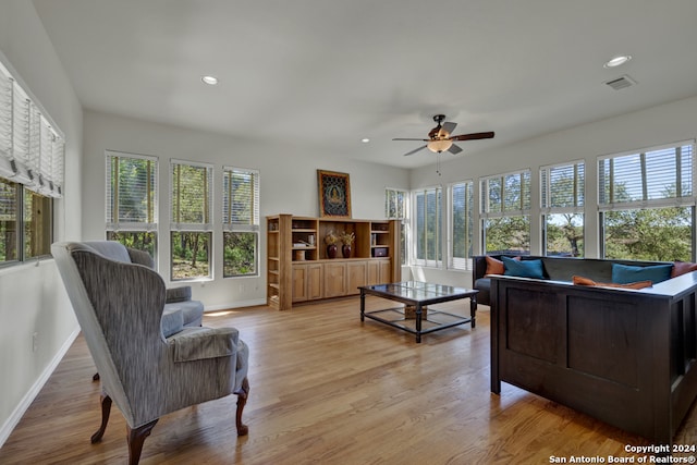 living room featuring light hardwood / wood-style floors, ceiling fan, and a wealth of natural light