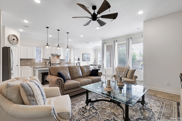 living room with ceiling fan and sink