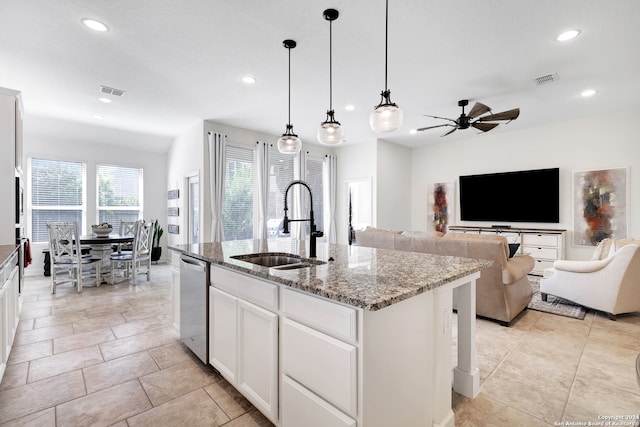 kitchen featuring a kitchen island with sink, sink, white cabinetry, light stone countertops, and ceiling fan