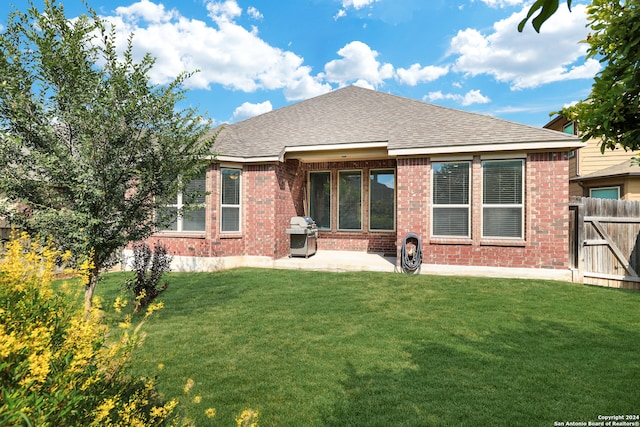 back of house featuring a patio and a yard