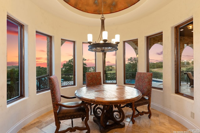 dining room featuring an inviting chandelier and a raised ceiling