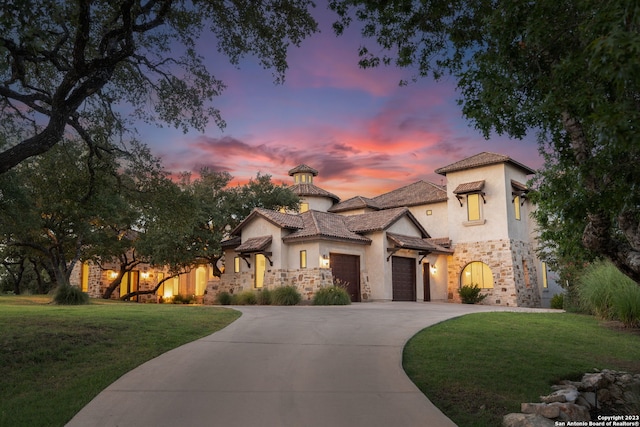 mediterranean / spanish-style house featuring a lawn and a garage