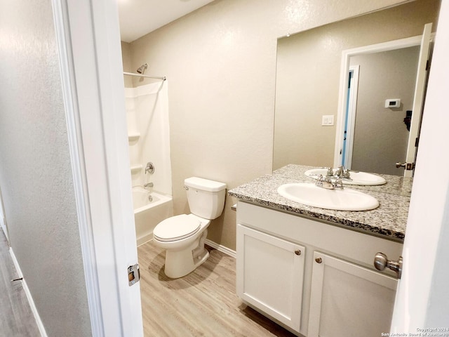 full bathroom with washtub / shower combination, wood-type flooring, vanity, and toilet