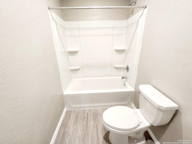 bathroom with tub / shower combination, toilet, and wood-type flooring