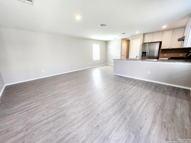 unfurnished living room with light wood-type flooring and sink