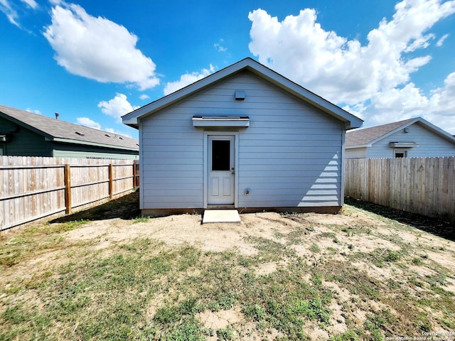 rear view of property with a lawn and an outdoor structure