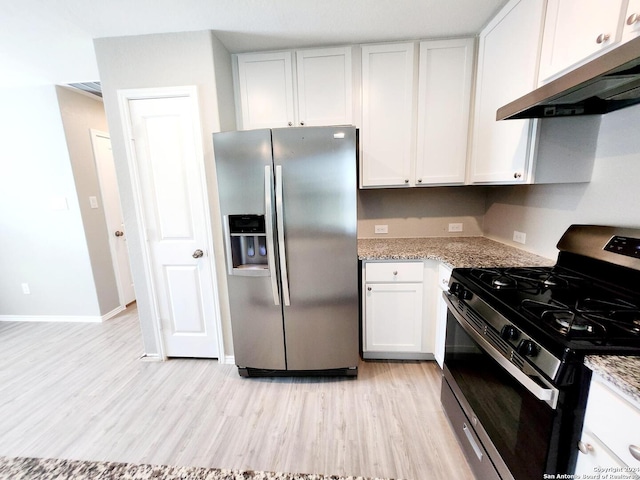 kitchen with light stone counters, white cabinets, appliances with stainless steel finishes, and light hardwood / wood-style floors