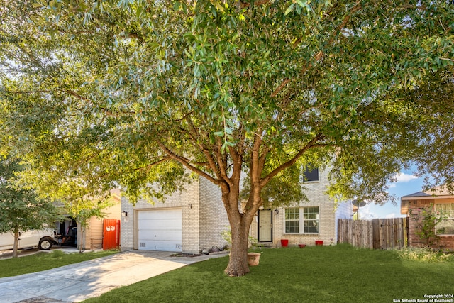 obstructed view of property with a garage and a front lawn