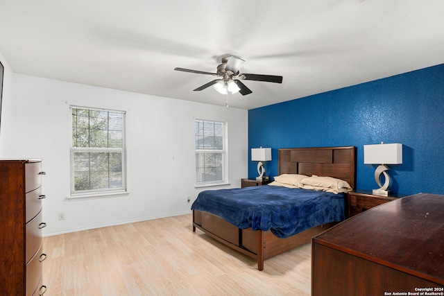 bedroom with light hardwood / wood-style flooring, multiple windows, and ceiling fan