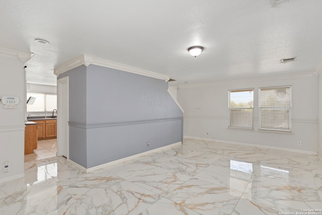 unfurnished room with a healthy amount of sunlight, crown molding, and a textured ceiling