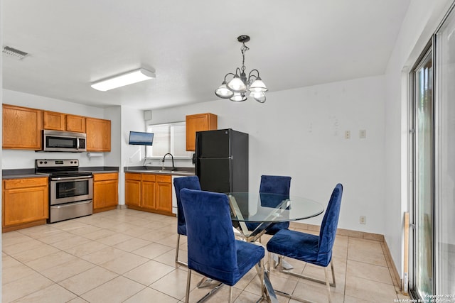 kitchen with light tile patterned floors, sink, decorative light fixtures, appliances with stainless steel finishes, and an inviting chandelier