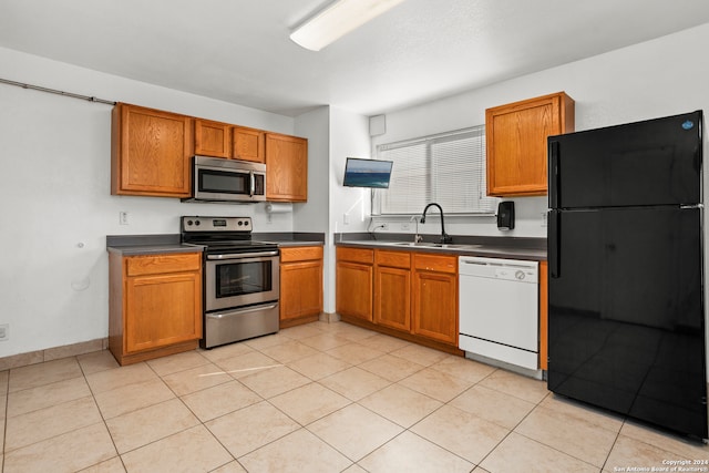 kitchen featuring light tile patterned floors, stainless steel appliances, and sink