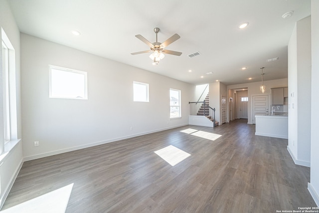 10280 Bartenheim Dr, Schertz, TX 78154 - unfurnished living room featuring stairs, wood finished floors, ceiling fan, recessed lighting, and baseboards