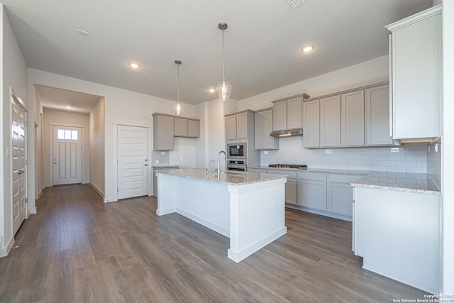 10280 Bartenheim Dr, Schertz, TX 78154 - kitchen with gray cabinets, appliances with stainless steel finishes, dark wood finished floors, decorative backsplash, and light stone countertops