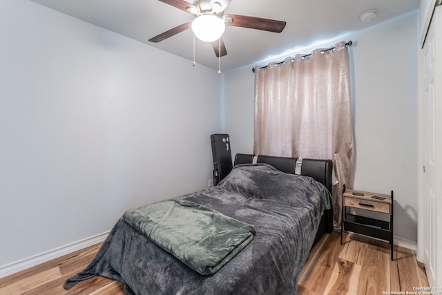 bedroom featuring ceiling fan, hardwood / wood-style flooring, and a closet