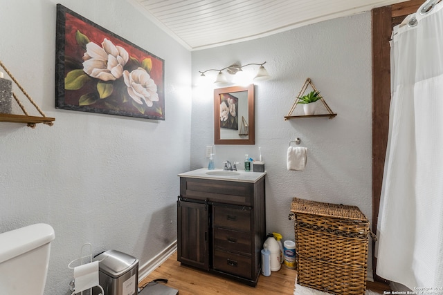 bathroom featuring vanity, hardwood / wood-style floors, toilet, and crown molding