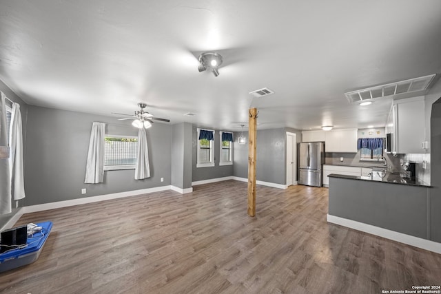 kitchen featuring stainless steel refrigerator, white cabinetry, decorative backsplash, and dark wood-type flooring