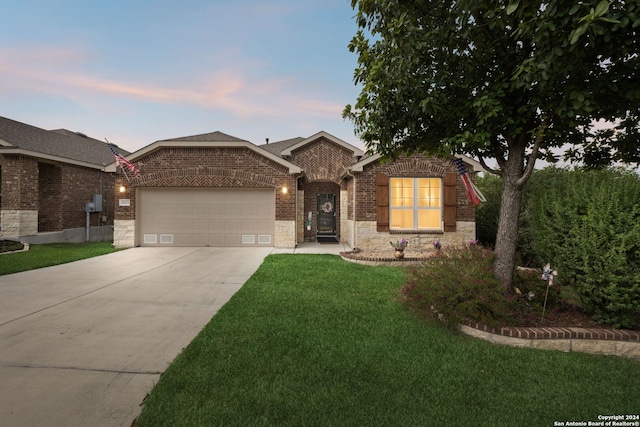 view of front facade featuring a garage and a yard