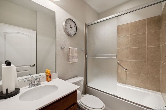 full bathroom featuring bath / shower combo with glass door, vanity, and toilet