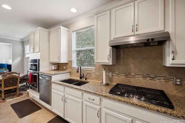 kitchen with light stone counters, sink, white cabinets, appliances with stainless steel finishes, and ornamental molding