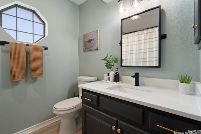 bathroom with wood-type flooring, vanity, and toilet