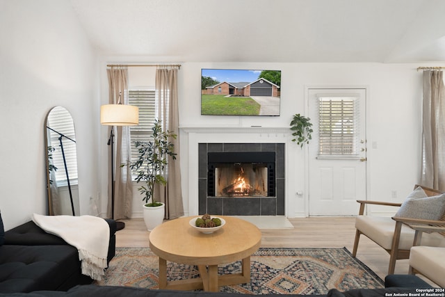 living room featuring hardwood / wood-style flooring and a tiled fireplace