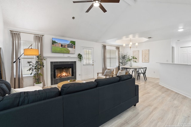 living room with ceiling fan with notable chandelier, vaulted ceiling with beams, light hardwood / wood-style floors, and a fireplace