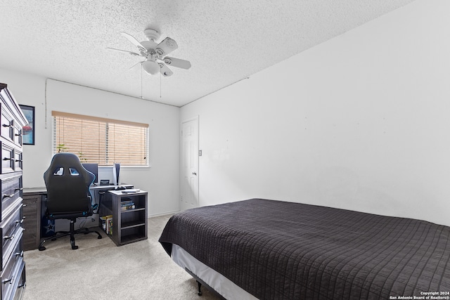 carpeted bedroom featuring a textured ceiling and ceiling fan