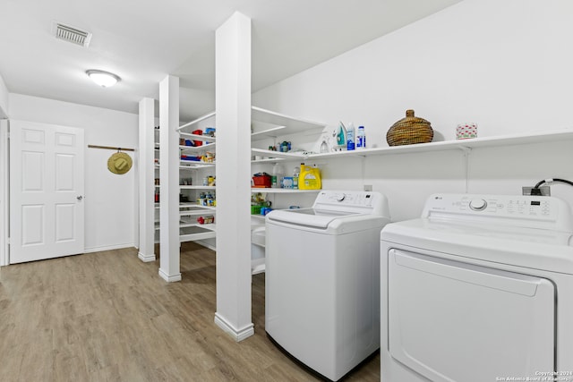 washroom with washer and clothes dryer and light hardwood / wood-style floors