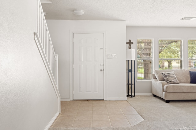 tiled entryway featuring a textured ceiling