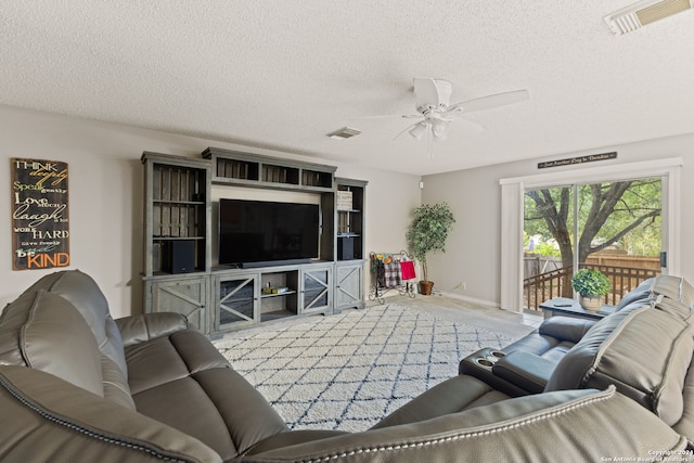 living room featuring ceiling fan and a textured ceiling