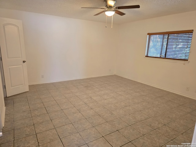 unfurnished room with ceiling fan and a textured ceiling