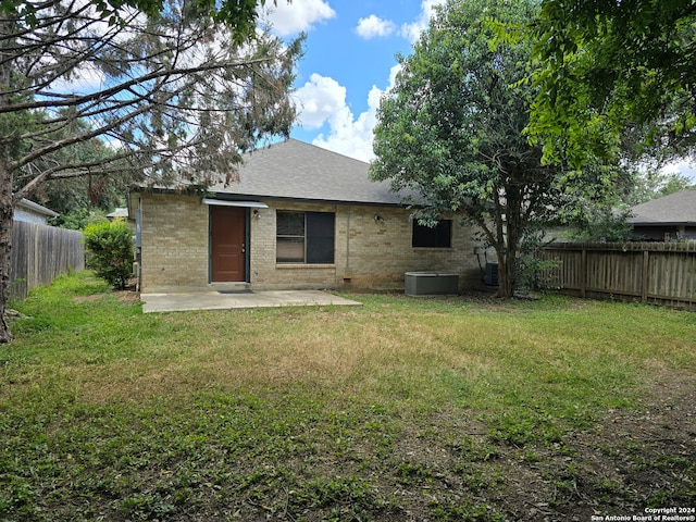 rear view of house with a lawn and central air condition unit