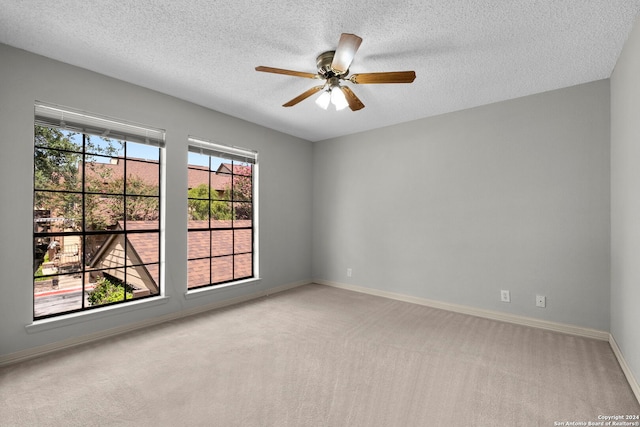 carpeted spare room with a textured ceiling and ceiling fan