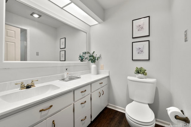 bathroom featuring wood-type flooring, vanity, and toilet