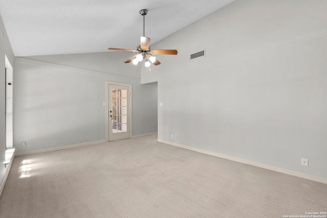 carpeted spare room with ceiling fan and vaulted ceiling