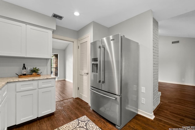 kitchen featuring light stone counters, white cabinets, high quality fridge, dark wood-type flooring, and vaulted ceiling