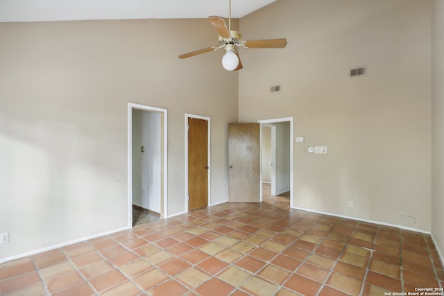 tiled spare room with ceiling fan and high vaulted ceiling