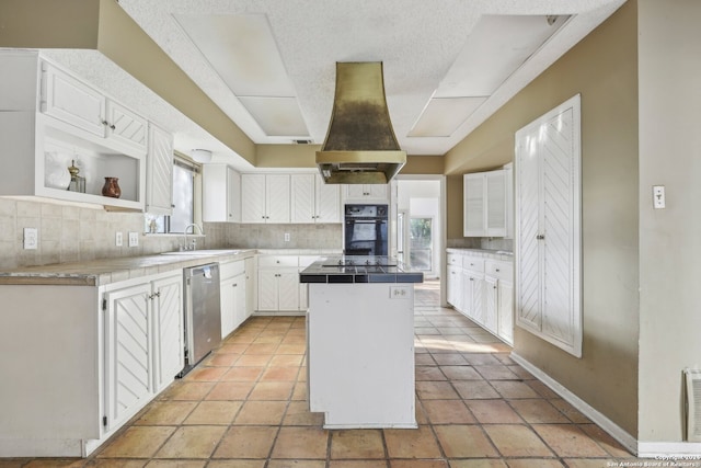 kitchen featuring a healthy amount of sunlight, a kitchen island, and white cabinetry