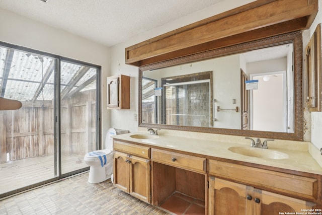 bathroom featuring a textured ceiling, a shower with shower door, vanity, and toilet