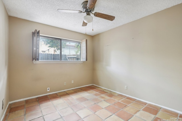 tiled spare room featuring ceiling fan and a textured ceiling