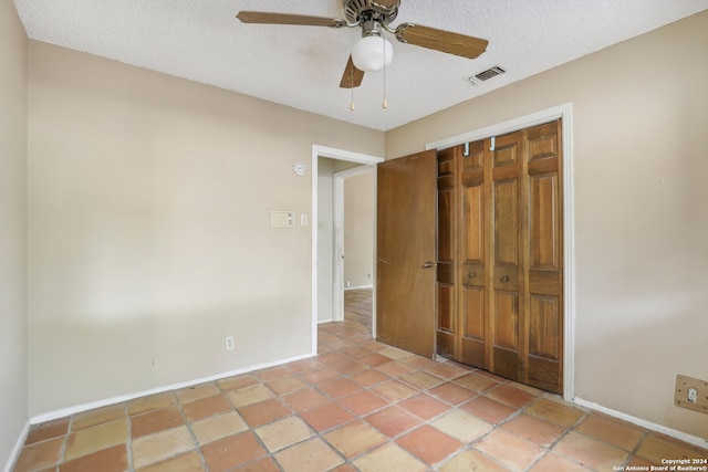 unfurnished bedroom with ceiling fan, a textured ceiling, and a closet