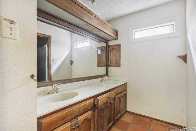 bathroom with vanity, tile patterned flooring, and a textured ceiling