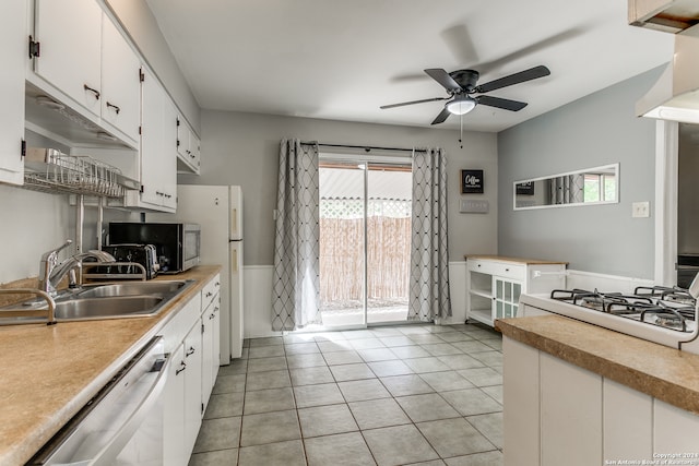 kitchen with ceiling fan, appliances with stainless steel finishes, white cabinetry, light tile patterned flooring, and sink