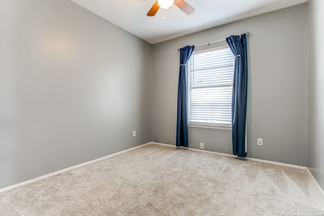 carpeted spare room featuring ceiling fan